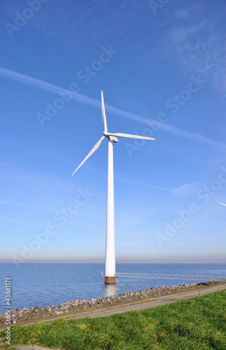Modern windmill in the water near the shore