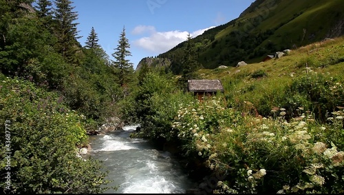 woman walking along a rive in the Alps