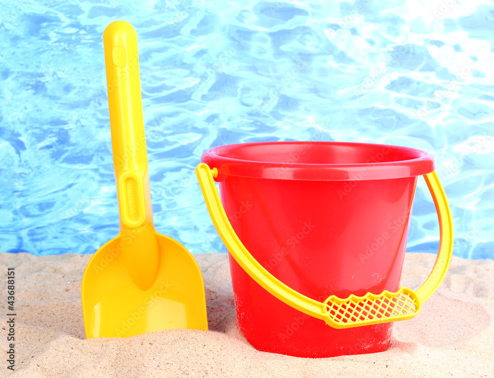 Children's beach toys on sand on water background Children's beach toys on sand on water background