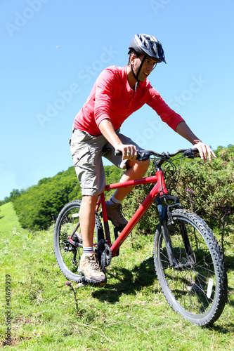 Man riding mountain bike in summertime