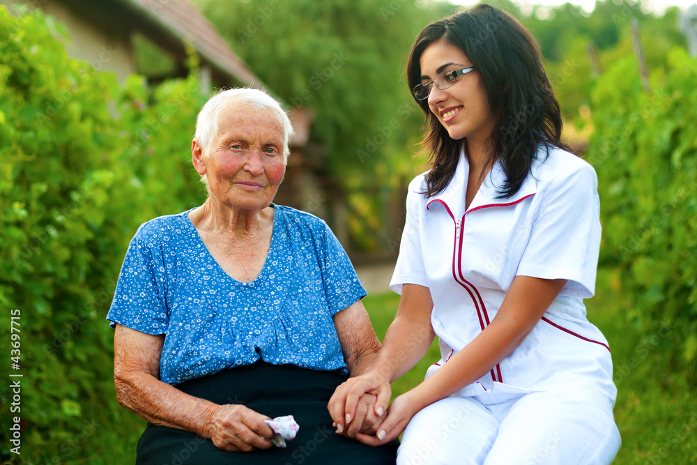 Obraz premium Caring doctor with sick elderly woman outdoors