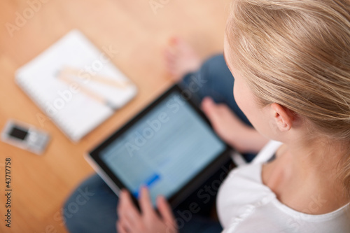 Young beautiful female female student using a tablet computer 