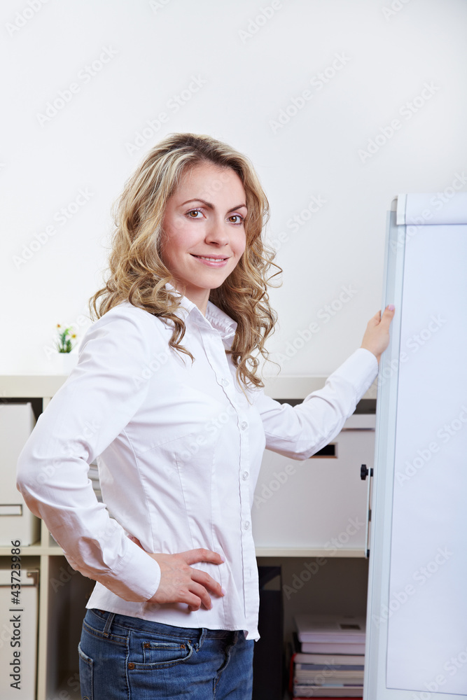 Frau neben Flipchart im Büro Frau neben Flipchart im Büro