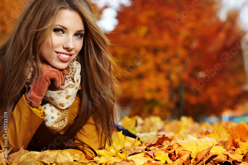 Portrait of very beautiful young woman in autumn park photo