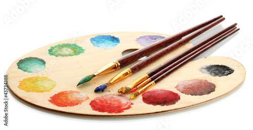 wooden art palette with paint and brushes isolated on white