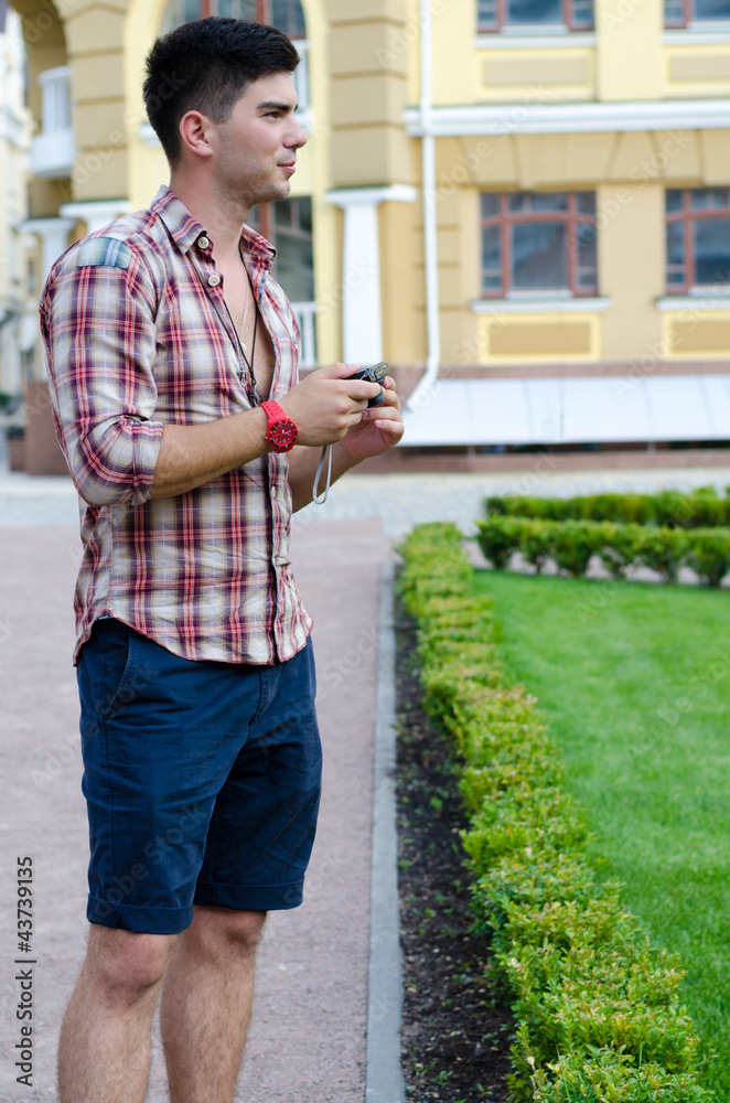 Man holding his camera while sightseeing Man holding his camera while sightseeing