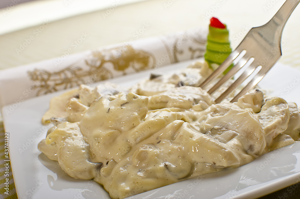 Mushrooms and white garlic sauce on a white plate. Mushrooms and white garlic sauce on a white plate.