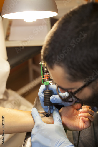 Photography chico tatuando a chica en la mano