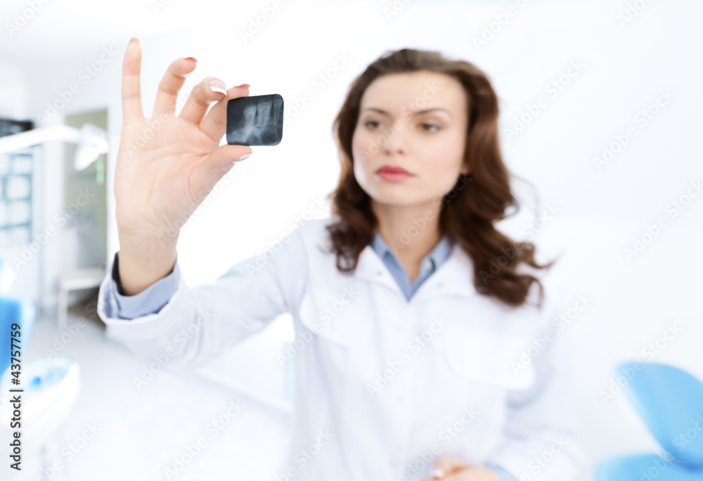 Dentist's assistant examines the x ray image in details Dentist's assistant examines the x ray image in details