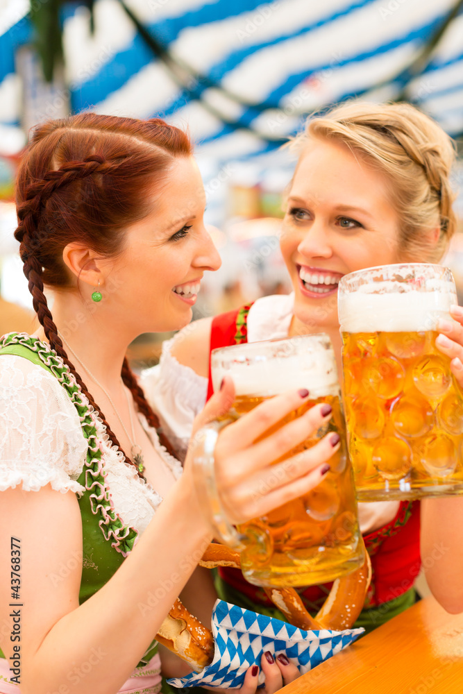 Junge Frauen in traditionellem Dirndl in Bierzelt Junge Frauen in traditionellem Dirndl in Bierzelt