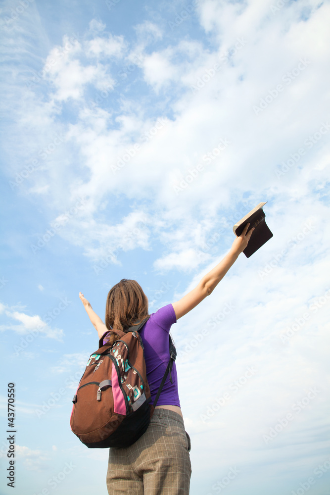 Teenage girl staying with raised hands