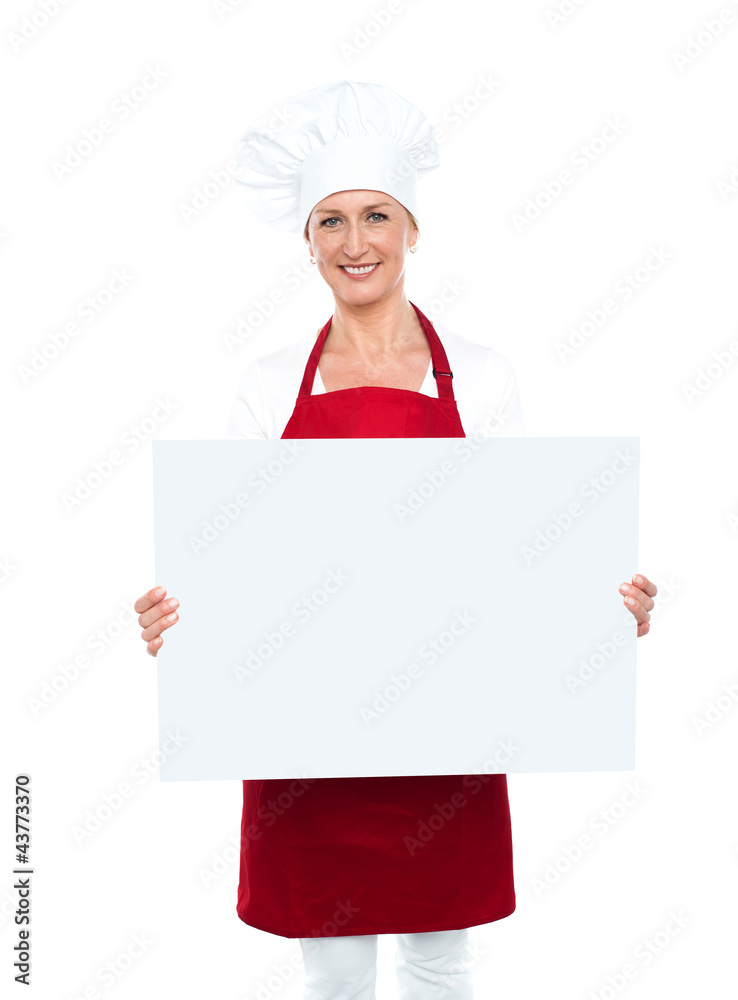 Happy female chef displaying white billboard Happy female chef displaying white billboard