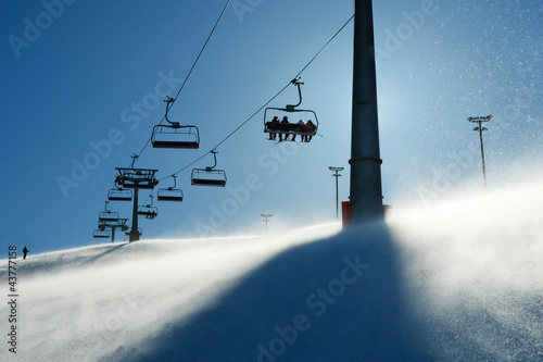 backlit scenes with ski lift chairs
