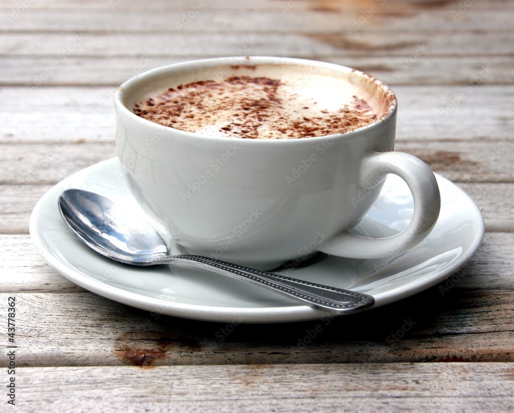 Cup of Cappuccino on wooden slat table