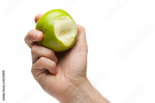 Hand holding green apple with bite missing