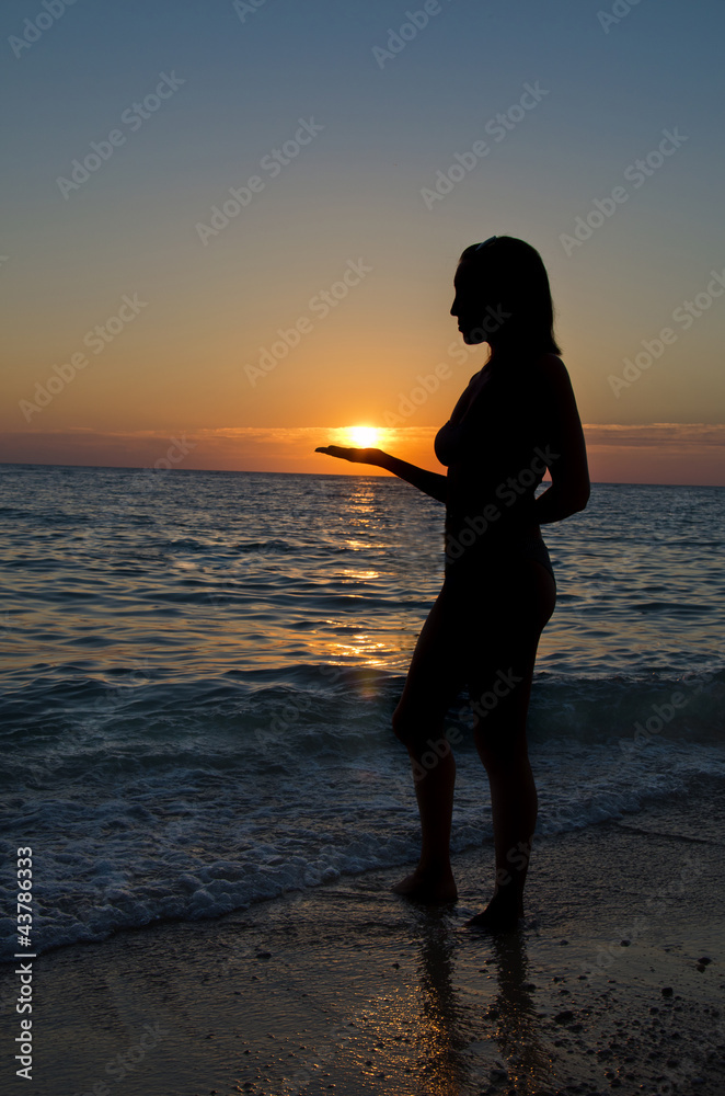 silhouette of girl holding a sun
