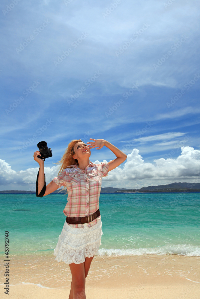 南国沖縄の美しいビーチで撮影を楽しむ笑顔の女性
