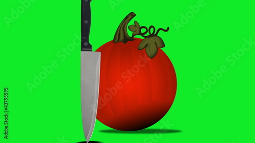 A knife meets a pumpkin on a green screen.