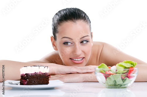woman choosing between healthy food and tasty cakes