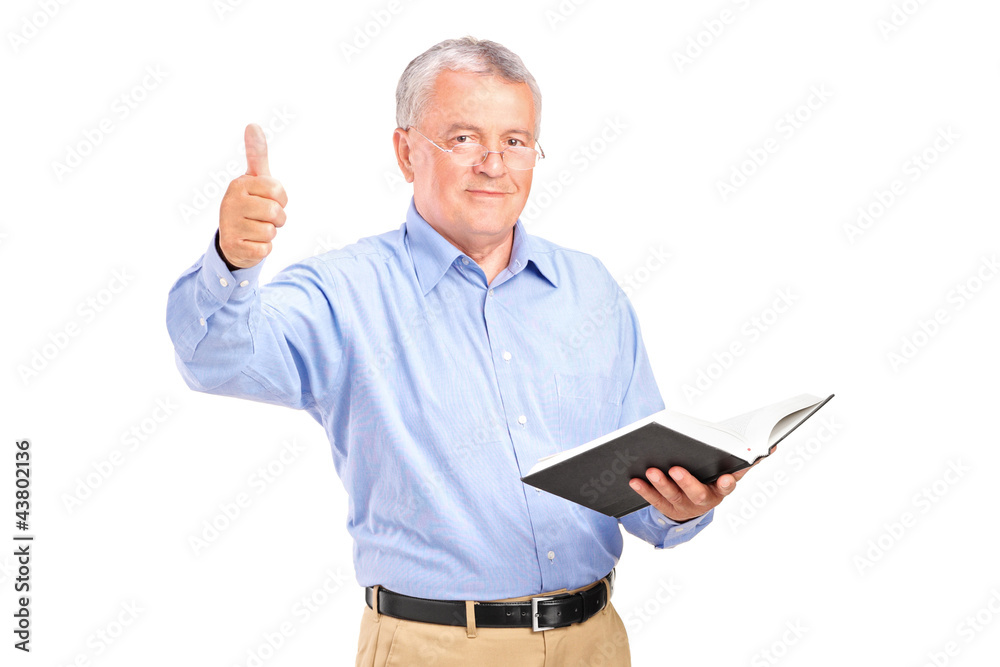 A male teacher holding a book and giving a thumb up A male teacher holding a book and giving a thumb up