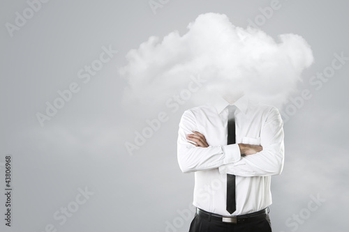 Young businessman with head in the clouds photo