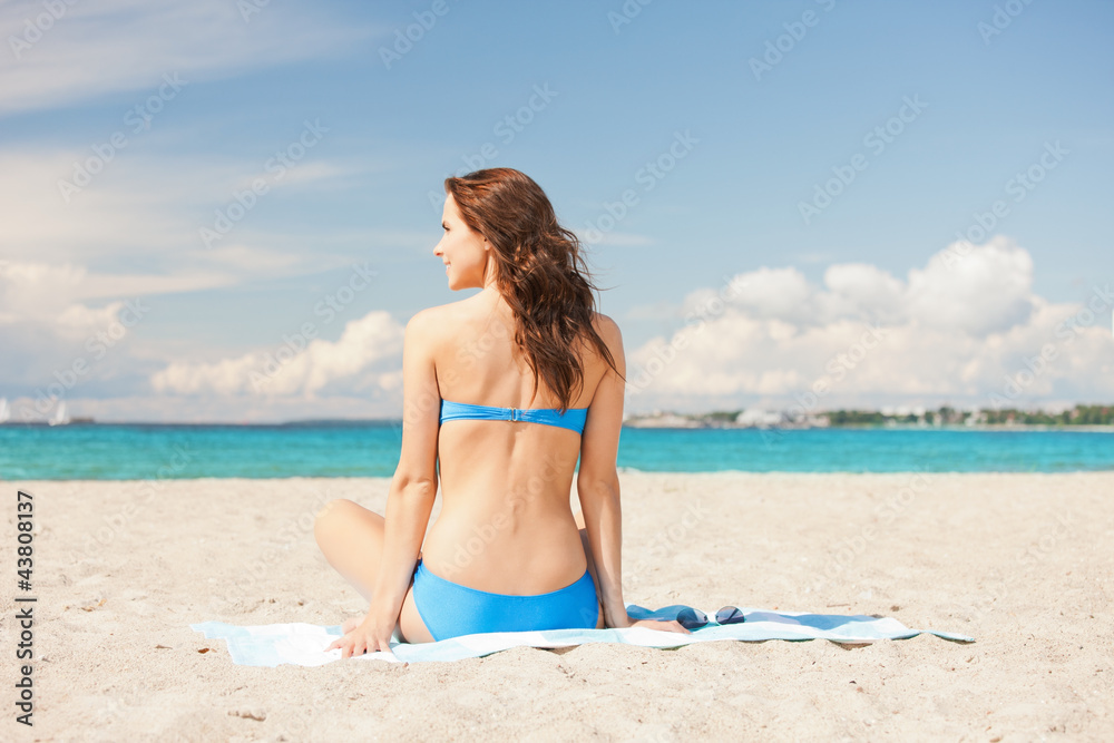 happy smiling woman sitting on a towel