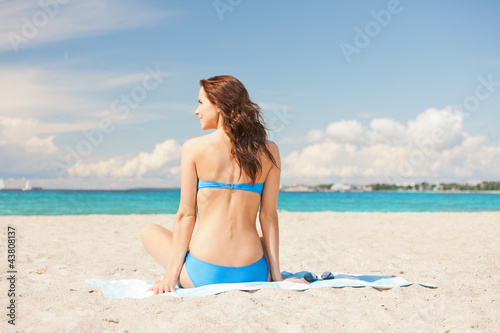 happy smiling woman sitting on a towel