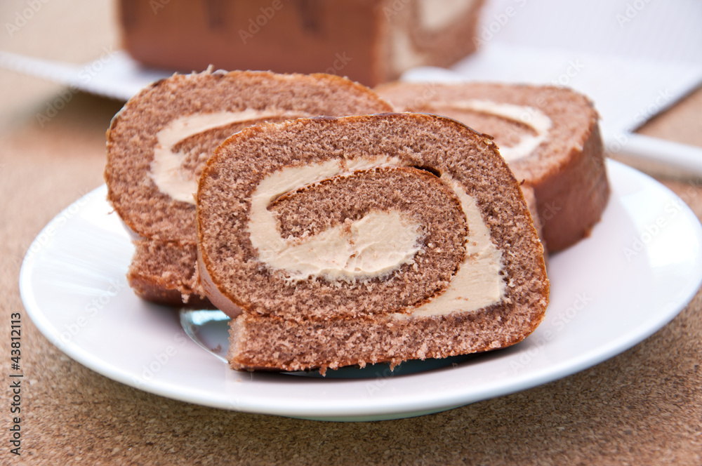 Swiss Sponge Roll With Cream on White Plate 