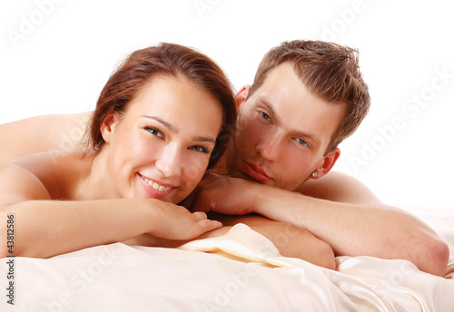 A loving affectionate nude heterosexual couple on the bed