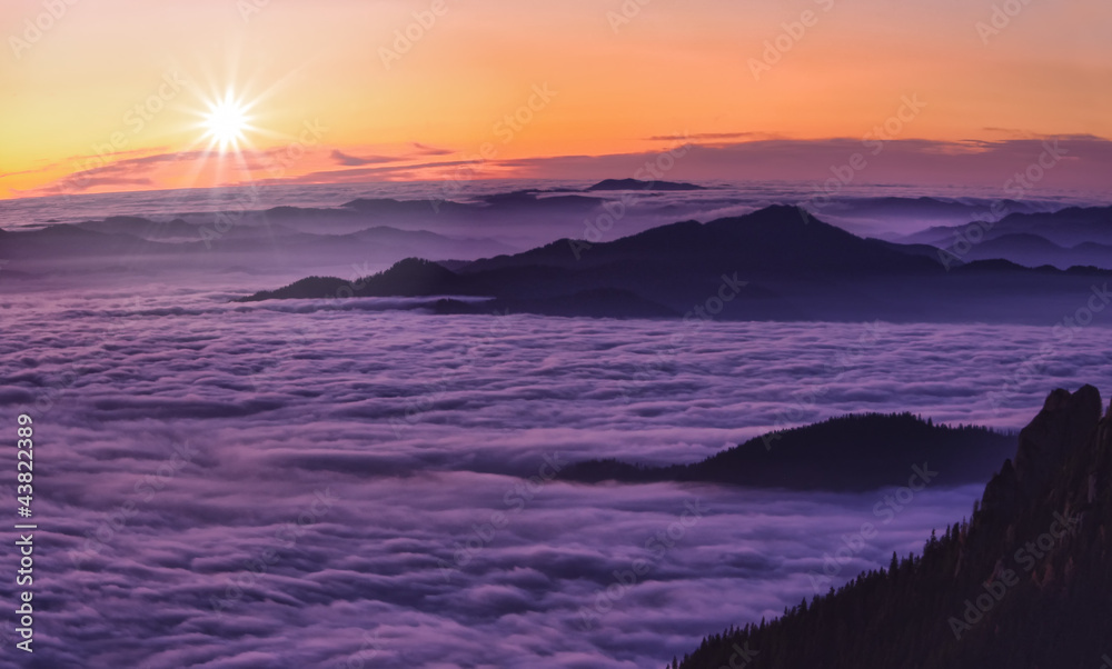 mountain sunset above clouds