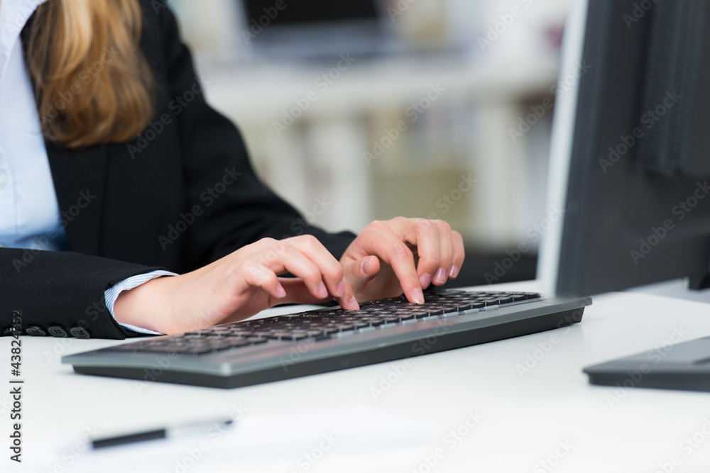 junge frau schreibt auf einer computertastatur junge frau schreibt auf einer computertastatur