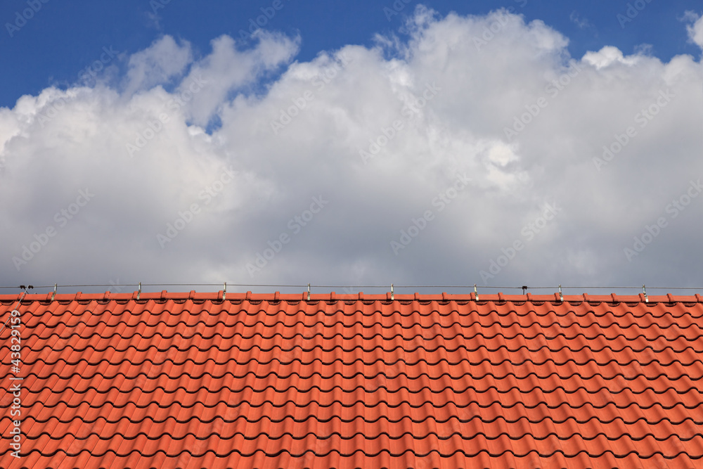 Red clay tiles roof pattern on blue sky background Red clay tiles roof pattern on blue sky background