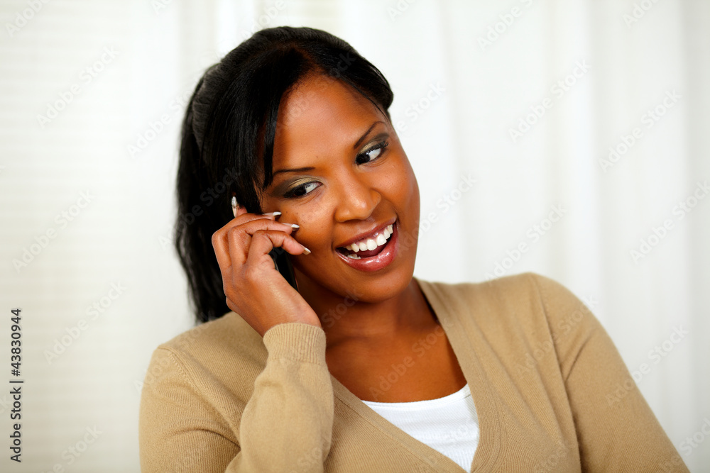 Young lady looking down while talking on cellphone Young lady looking down while talking on cellphone