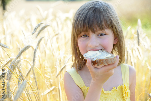 Mädchen mit Butterbrot im Roggenfeld