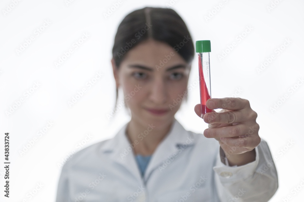 Medico mirando probeta con fluido rojo Medico mirando probeta con fluido rojo