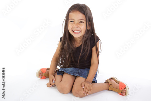 Foto enfant assise souriante sur fond blanc