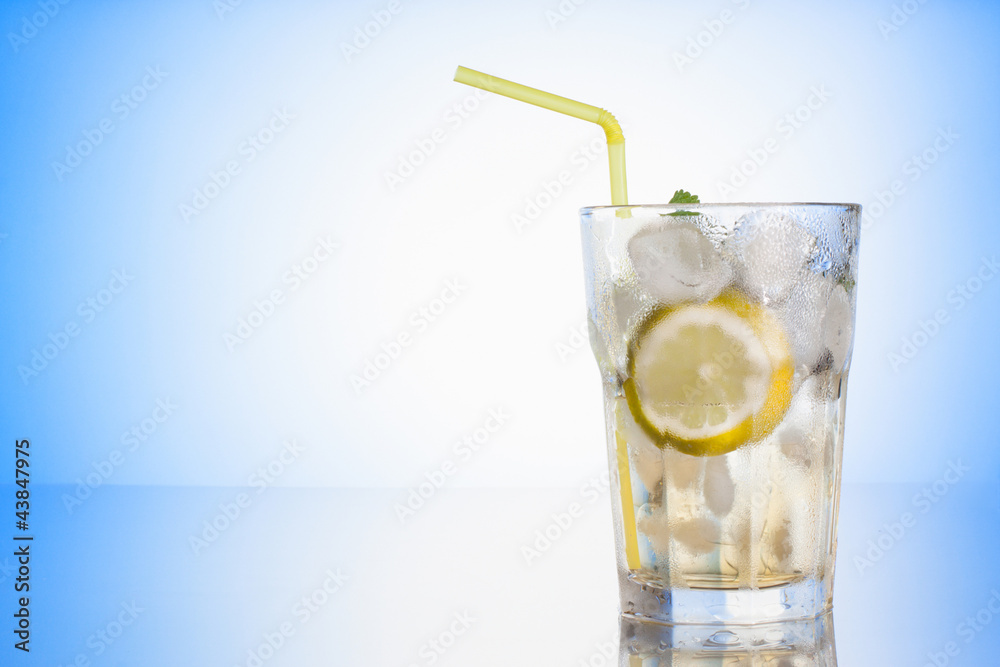 Glass with ice lemonade on blue background Glass with ice lemonade on blue background
