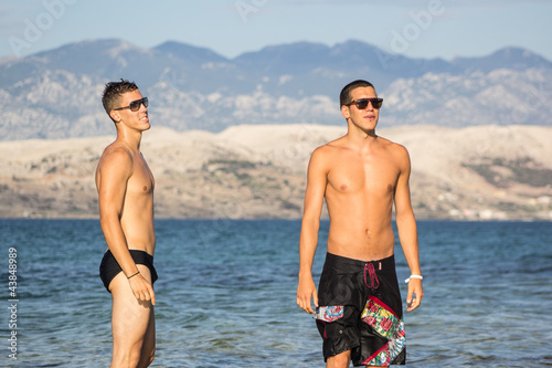 Handsome friends, playing into the sea