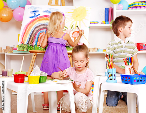 Child painting at easel. photo