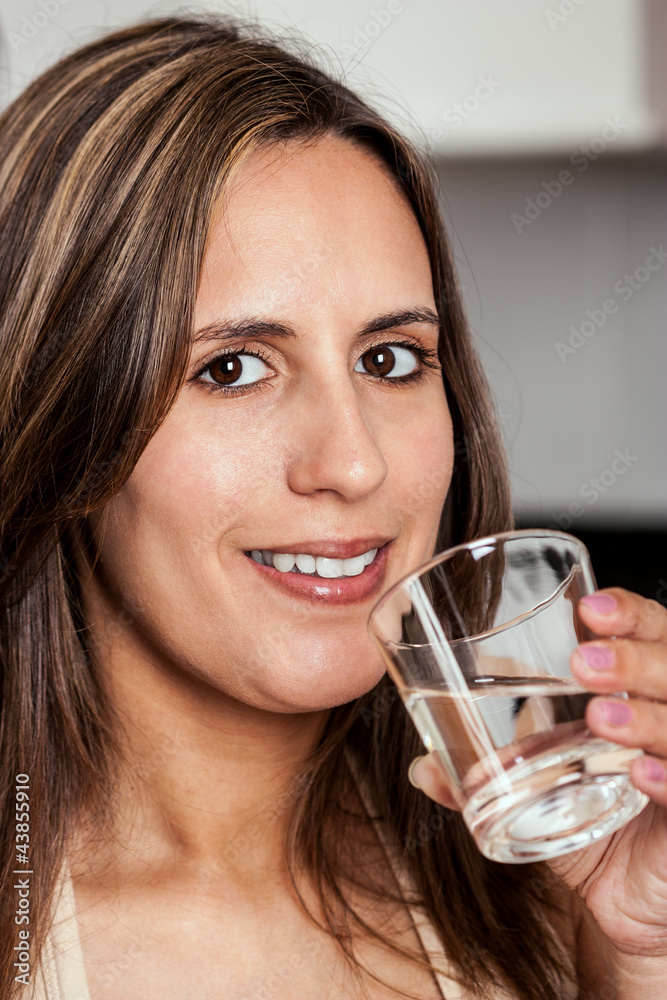 Woman smiling with a glass of water Woman smiling with a glass of water