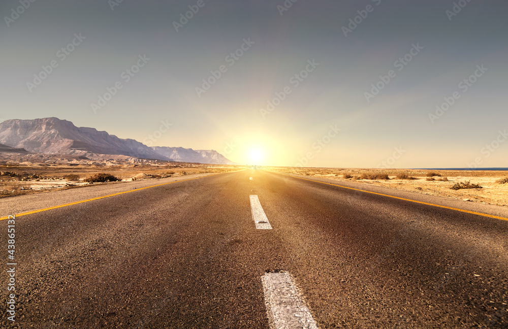 Naklejka premium Road in the desert and sunset