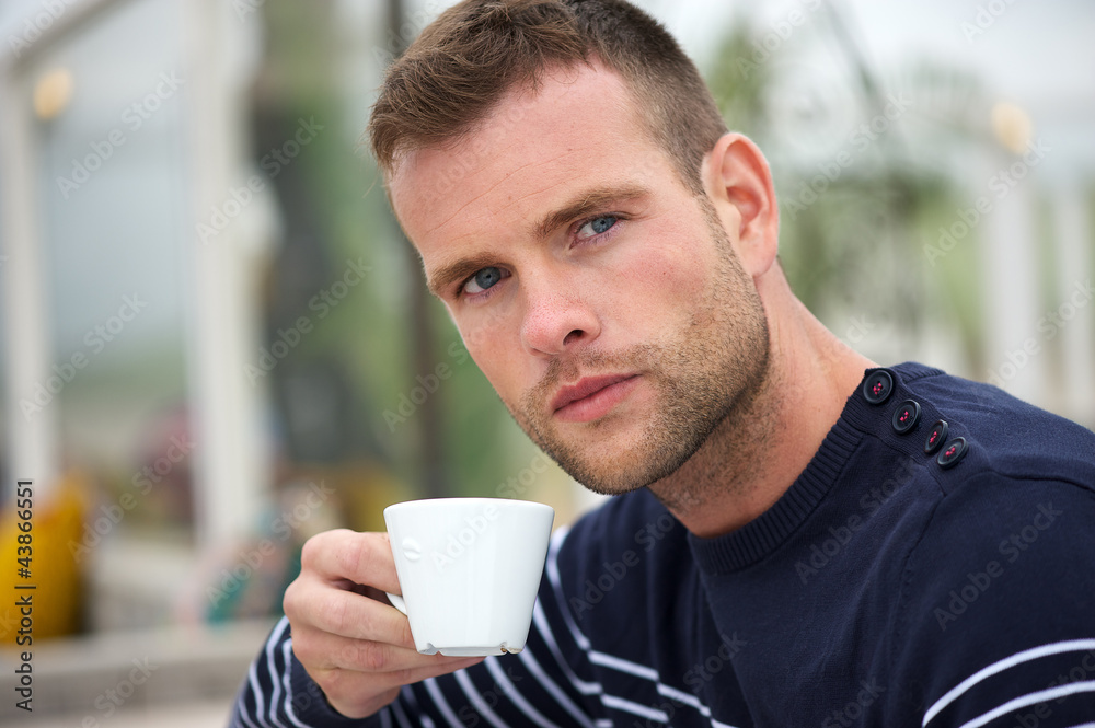 Young Man Drinking his Coffee at the Beach Young Man Drinking his Coffee at the Beach