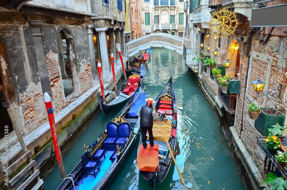 typical urban view with canal, boats and houses in Venice