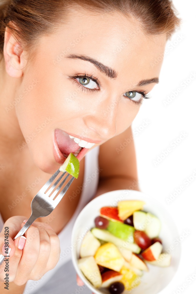 Slim young woman eating fruit salad Slim young woman eating fruit salad