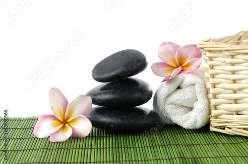 Zen stones and roller towel and wicker basket with frangipani