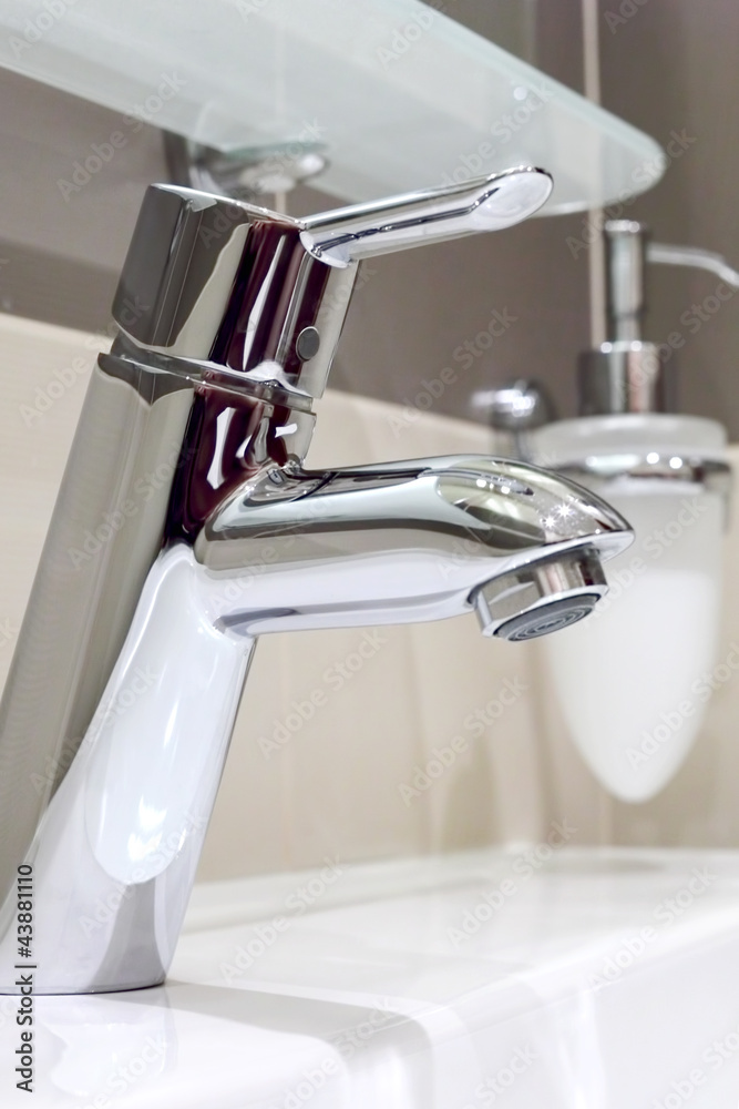 The metal tap and sink in bathroom. The metal tap and sink in bathroom.