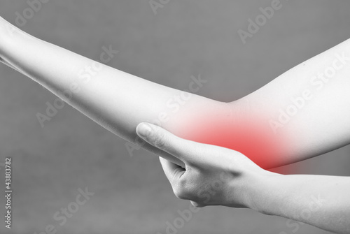 Acute pain in a woman wrist. Female holding hand to spot of wris photo