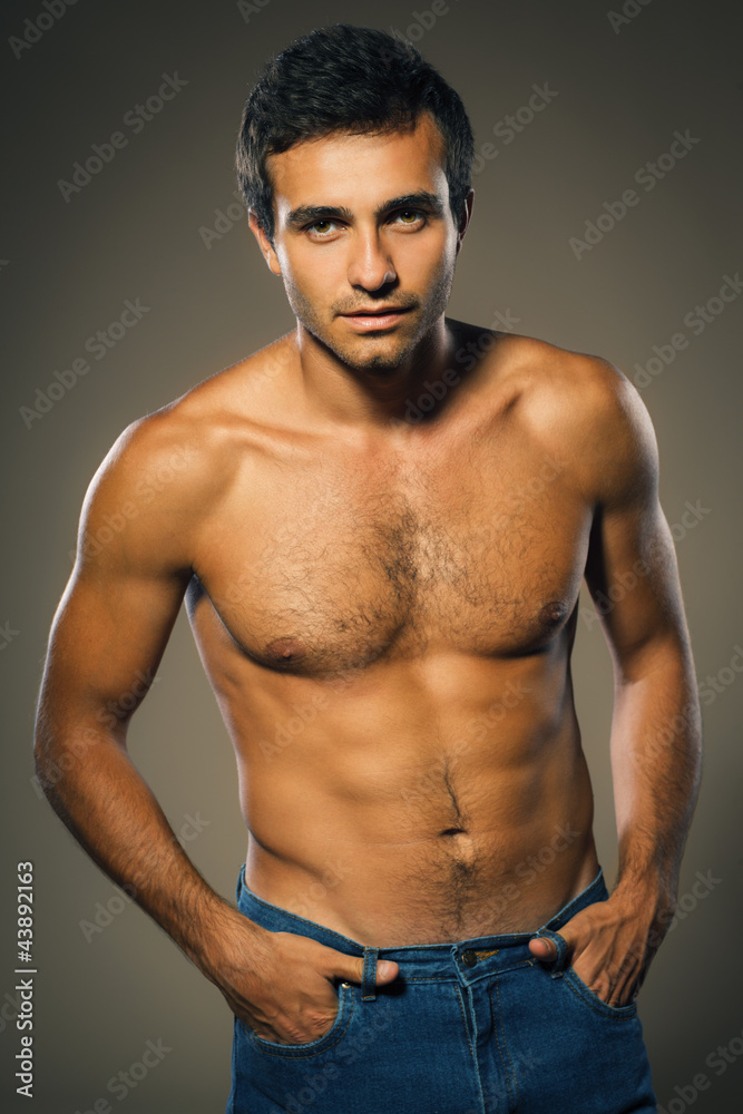 Young muscular male shirtless standing with hands in pocket Young muscular male shirtless standing with hands in pocket