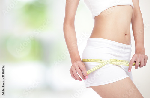 Woman measuring perfect shape of beautiful hips