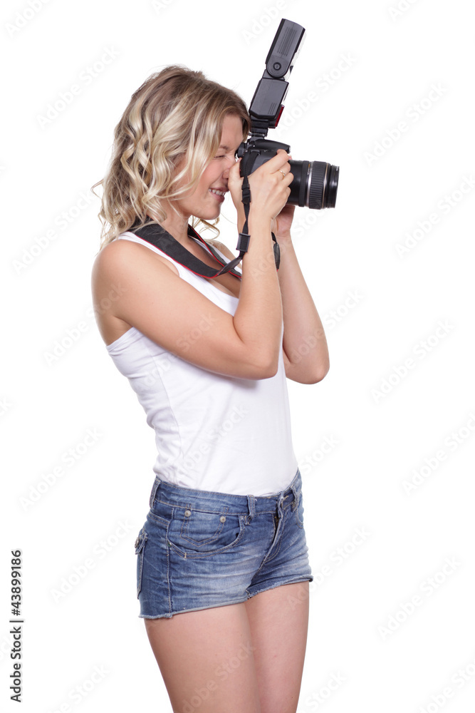 Cheerful woman shooting with a camera against white background Cheerful woman shooting with a camera against white background